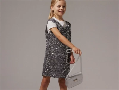 Pige iført Name It paillet spencerkjole lava smoke