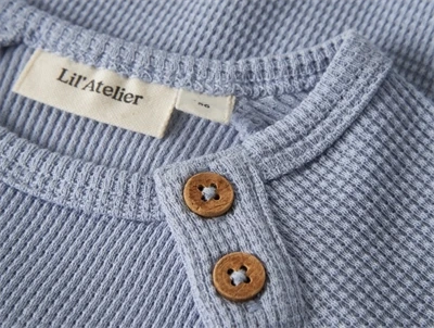 Lil\' Atelier body i støvet blå nuance med knapdetalje
