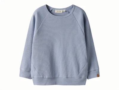 Lil' Atelier bluse i støvet blå nuance med struktur set forfra