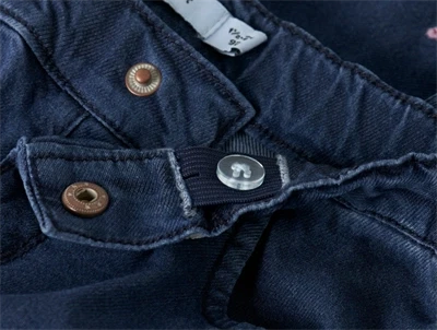 Detalje af trykknap og justerbar linning på mørkeblå Name It jeans