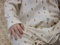 baby iført lil\' atelier heldragt med pæreprint, hånd på benet