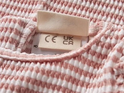 Lil\' Atelier UV dragt i rosa nuance med flæsedetalje