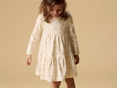 Pige iklædt Lil' Atelier kjole i råhvid nuance med blomsterprint