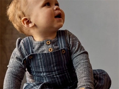 Barn iklædt Name It overall i blå nuance med knaplukning på stropper