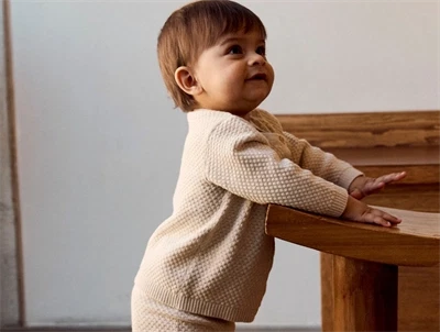 Barn iklædt i Name It strik cardigan i beige nuance med struktur