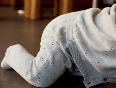 Barn iklædt Name It strikbukser i beige nuance med hulmønster