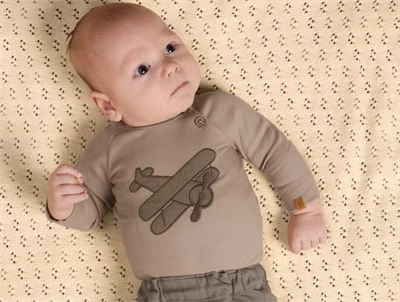 Baby iklædt Lil' Atelier body i beige nuance med fly print