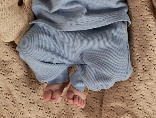 Baby iklædt Lil Atelier bukser i blå nuance med ribkanter og snøre