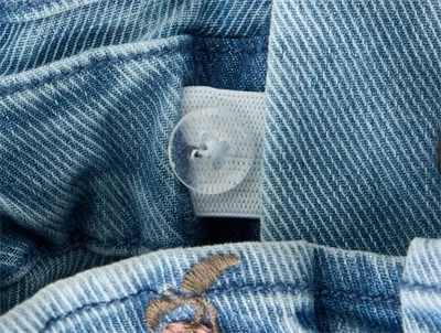 Detalje af justerbar knaphulselastik og denim på Lil\' Atelier jeans til børn