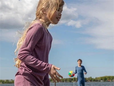 Pige iklædt Joha bluse i lilla nuance med lange ærmer i uld og silke