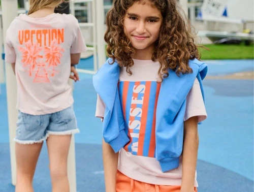 pige iført rosa kisses t-shirt fra kids only med blå trøje over skuldrene