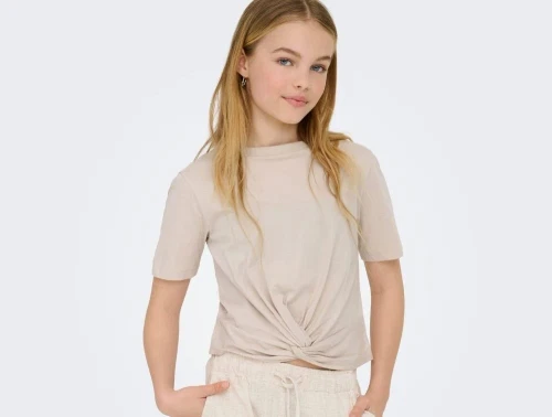pige iført beige t-shirt fra kids only med twistdetalje og løstsiddende pasform