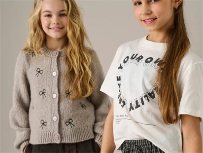 Pige iklædt KIDS ONLY cardigan pumice stone med sløjfedetaljer til piger