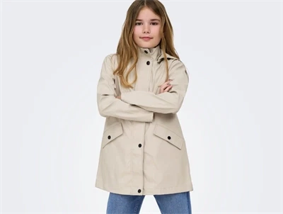 Pige iklædt Kids Only regnjakke i lys beige nuance silver lining med hætte