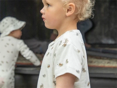 Pige iklædt Joha t-shirt i råhvid nuance med krabbeprint og korte ærmer i uld og silke