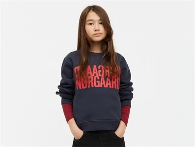 Barn iført mørkeblå Mads Nørgaard sweatshirt med rødt logo