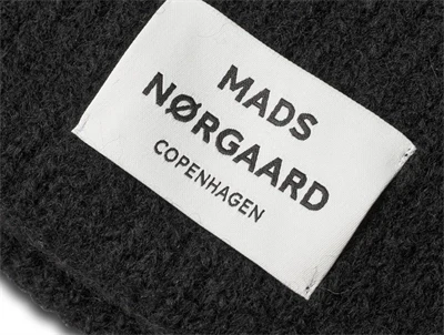 Nærbillede af logolabel på sort Anju hue fra Mads Nørgaard