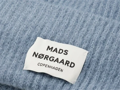 Nærbillede af Mads Nørgaard logo på lyseblå hue