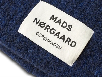 Nærbillede af Nørgaard hue i mørkeblå med logo
