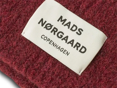 Close-up af Mads Nørgaard hue i winery med logo