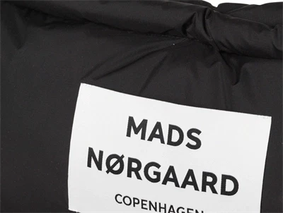Nærbillede af Mads Nørgaard logo på sort puffertaske