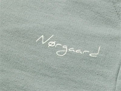 Nærbillede af logoprint på Mads Nørgaard sweatpants i slate grey