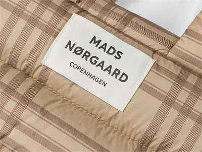 Logo på Mads Nørgaard taske i ternet brun nuance