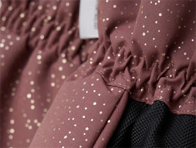 Detaljebillede af En Fant luffer i frosted almond med guldprikker og sort greb