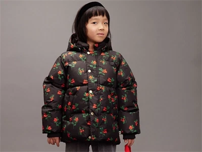 barn iført Mini Rodini sort pufferjakke med rødt bærprint