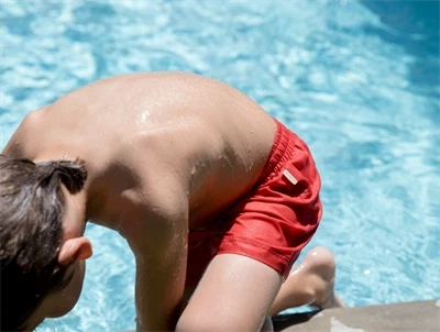 Barn iklædt MarMar Swiggo badeshorts i rød nuance