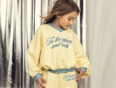 Pige iklædt Mini Rodini sweatshirt i yellow med to the moon broderi