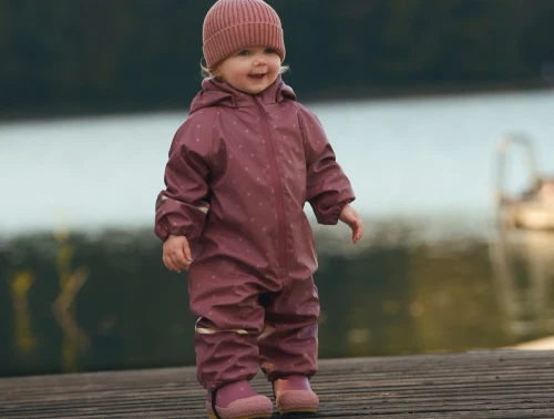 Pige iklædt CeLaVi regndragt i lilla nuance med prikker og fleecefoer