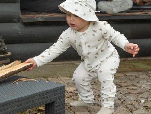 Barn iklædt Joha heldragt i råhvid nuance med krabbeprint i uld og silke