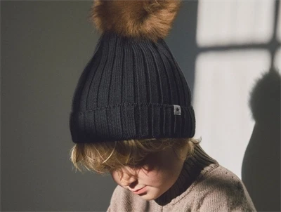 Huttelihut hue i mørkeblå nuance med pompon på model