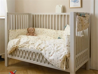 Cam Cam Copenhagen sengerand monteret i babyseng med vintage toys print