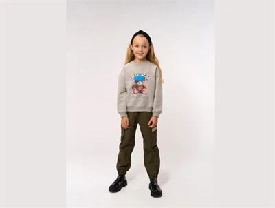 Pige iført grå sweatshirt fra THE NEW med teddy print