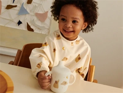 Liewood Merle cape hagesmæk i ecru med elefant print set forfra