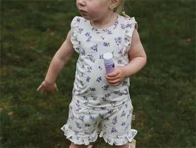 Petit Piao shorts i lys creme nuance med violprint og flæser på barn