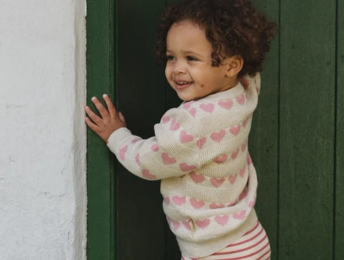 Pige iklædt Petit Piao cardigan med rosa hjerter
