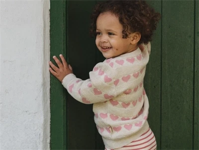 Pige iklædt Petit Piao cardigan med rosa hjerter
