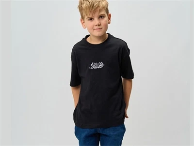 Barn iført t-shirt og der ses Forside af THE NEW TNRoss oversize t-shirt sort med grafisk print